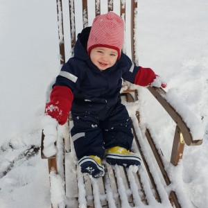 Kind auf Liegestuhl im Schnee