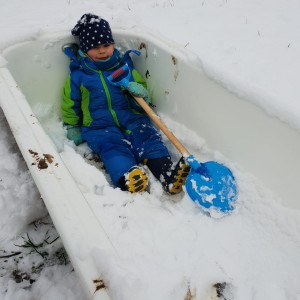 Kind in Badewanne im Schnee